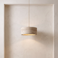 Kairi Travertine Pendant Light against a warm plaster wall